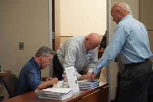 Juan Garcia, co-author of the “Drillers Knowledge Book”, left, and Ron Sweatman, author of “Well Cementing Operations”, sign their respective books for Tech Forum attendees.